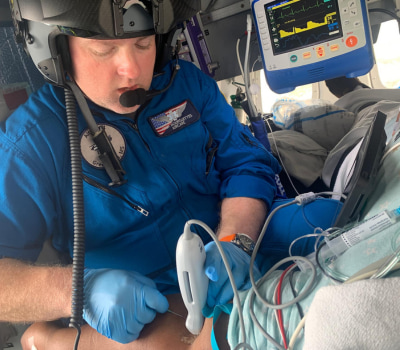 Inside the AirCare helicopter, a clinician uses ultrasound to start an IV